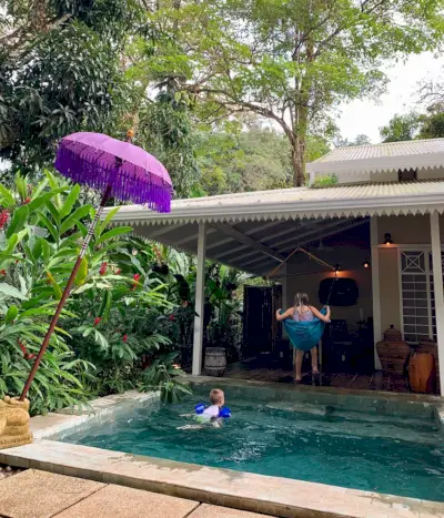 Kinderen spelen op tropische Airbnb in Costa Rica met zwembad en schommel