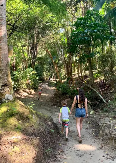 Moeder loopt met jonge kinderen naar het geheime strand Playa Biesanz in Costa Rica