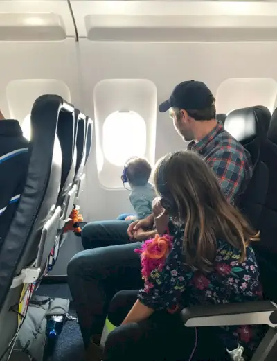 John en kinderen op vliegtuig naar de voorjaarsvakantie in Florida