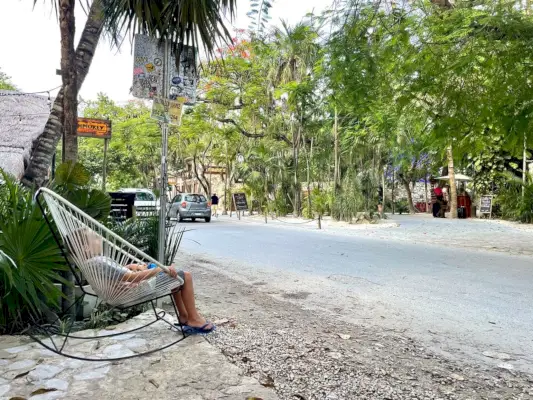 Kind zit in een schommelstoel vlakbij de weg in Tulum, Mexico