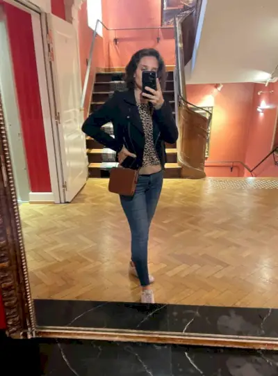 Siyah ceket ve tenis ayakkabılarının altında leopar kazaklı otel aynasında Sherry selfie'si