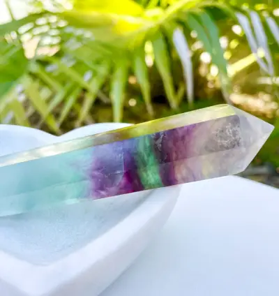 Regenboogfluorietkristal in stenen schotel met plan op de achtergrond