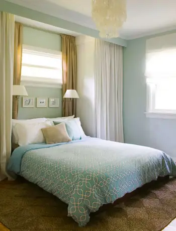 Colgar algunas persianas blancas de imitación de madera en el dormitorio