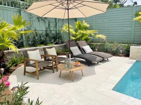Ronde patio bij het zwembad omgeven door tropische beplanting Chinese palmen, oleander, jasmijn, muurpeper, vossestaartvarens