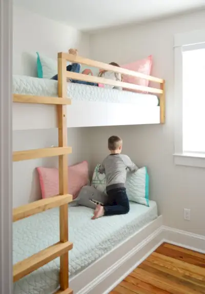 ingebouwde stapelbedden in een kleine kamer met kinderen op elk bed
