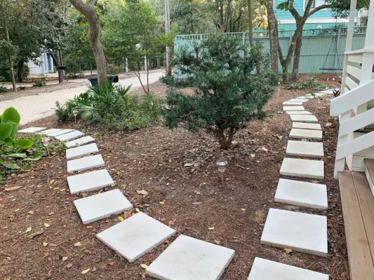 Vierkant wit bestratingspad rond mulch voortuin