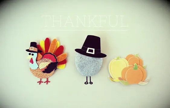 A turkey, pilgrim, and pumpkin patch made of felt cutout pieces