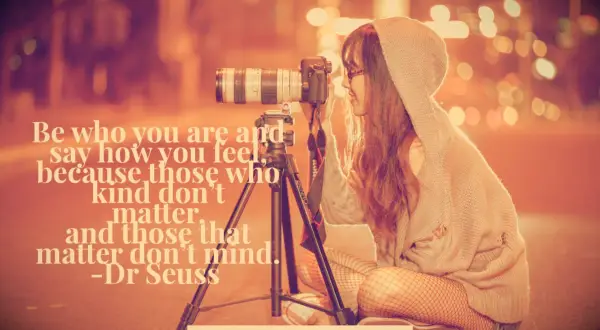 Profile of a girl taking a photograph with a camera on a tripod