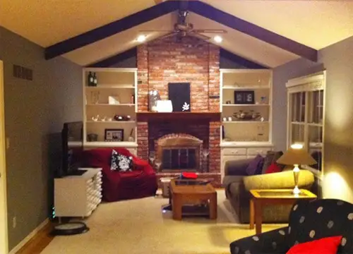Una chimenea de ladrillo blanco pintada en una sala de estar abovedada