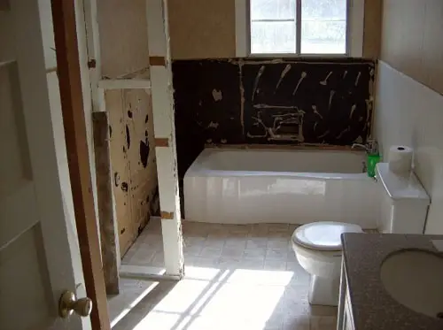 Een donkerblauwe badkamer met een hoekdouche